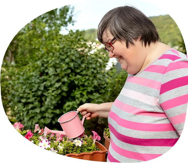 Woman Watering Plants — Supported Independent Living in Bundaberg, QLD